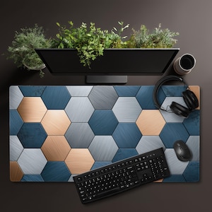 May include: A rectangular desk mat featuring a geometric pattern of interlocking hexagons in shades of metallic copper, brushed silver, and deep navy blue. The surface has a textured appearance with varying finishes across the hexagonal tiles.