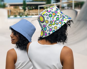 Könnte beinhalten: Zwei Personen tragen Bucket-Hats. Ein Hut ist hellblau und der andere ist weiß mit einem bunten Kreis-Muster.