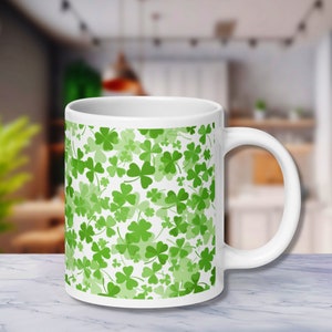 May include: White ceramic mug with a green shamrock pattern.
