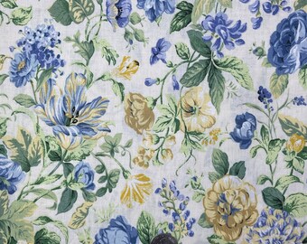 May include: A white fabric with a floral pattern featuring blue and yellow flowers. The fabric has a vintage feel and is perfect for crafting projects.