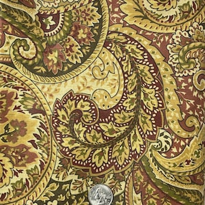 May include: A paisley fabric with a brown, gold, and green pattern. The fabric has a vintage feel and would be perfect for upholstery or quilting.