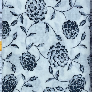 Könnte beinhalten: Weißer Stoff mit einem sich wiederholenden Muster aus dunkelblauen, stilisierten Blumen und Ranken. Der Stoff hat den Text "Threads of Time for Moda" am unteren Rand aufgedruckt.