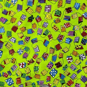 May include: A vibrant fabric featuring a repeating pattern of colorful, stylized flags or banners connected by thin green lines. The flags display various patterns, including polka dots, stripes, and geometric shapes, set against a bright green background. A quarter is included for scale.
