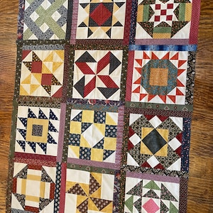 May include: A quilt with 12 different patchwork squares. Each square features a different pattern in a variety of colors, including red, blue, green, yellow, and white.