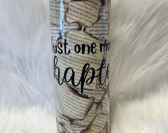 May include: A stainless steel tumbler with a book-themed design. The tumbler features a vintage book page pattern with burnt edges and the text "Just one more chapter" in black script.