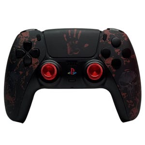 May include: A black PlayStation 5 DualSense controller with a red skull and blood splatter design. The controller has red thumbstick caps and a red handprint on the back.