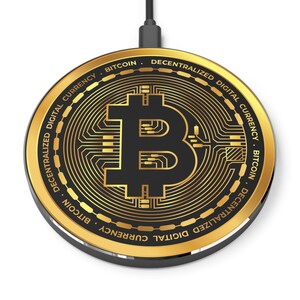 May include: A gold-colored wireless charging pad with a black Bitcoin logo in the center. The pad has the text "DECENTRALIZED DIGITAL CURRENCY. BITCOIN. DECENTRALIZED DIGITAL CURRENCY. BITCOIN" around the edge.