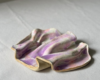 Handgefertigter Keramikuntersetzer in Wellenform – beigefarbener Ton mit Sprenkeln, weiße, rosa und violette Glasur