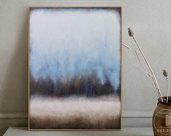 May include: Abstract painting with a blue, brown, and white color scheme. The painting is framed in a thin, gold frame. The painting is hanging on a wall.