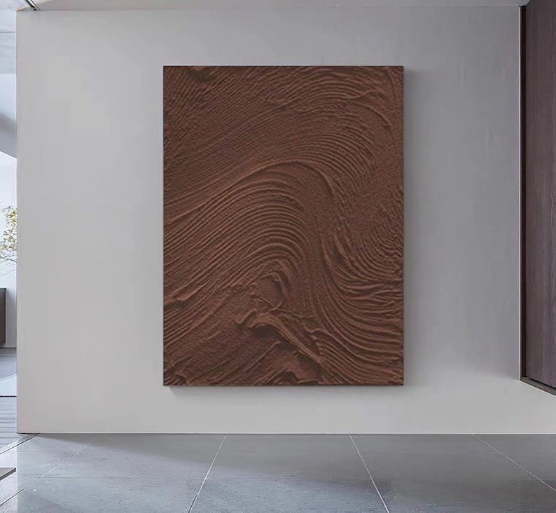 Puede incluir: Una pintura abstracta marr&oacute;n con una superficie texturizada. La pintura tiene un patr&oacute;n de l&iacute;neas y curvas en espiral.