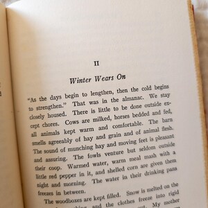 May include: Open book page with text titled "Winter Wears On." The text describes winter activities, including caring for animals and the effects of cold weather. The page has a cream-colored background with black text.