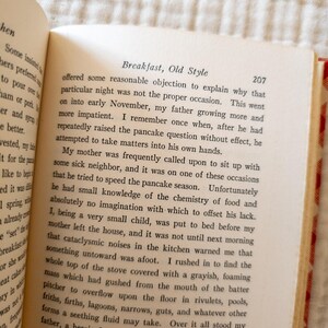 May include: Open book with text titled "Breakfast, Old Style" on a cream-colored page. The text is in black font. The book is open to page 207. The book's binding is red.