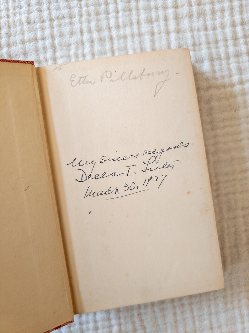 May include: Open book with handwritten inscription. The inscription reads "Etta Pillsbury" at the top, followed by "My sincere regards, Decca T. Selee, March 30, 1937." The pages are aged with a light tan color, and the binding is red.