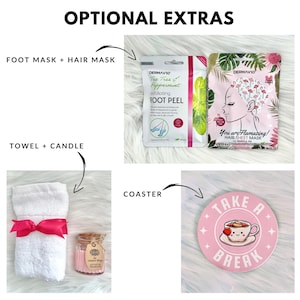 May include: A pink and white gift basket with optional extras. The basket includes a white towel with a pink ribbon, a small glass jar with a candle, a pink and white coaster with the text "Take a Break" and a cup of tea, and two packets of face masks. One packet is green and says "Tea Tree & Peppermint Exfoliating Foot Peel" and the other is pink and says "You are Flamazing! Hair Sheet Mask Marula Oil".