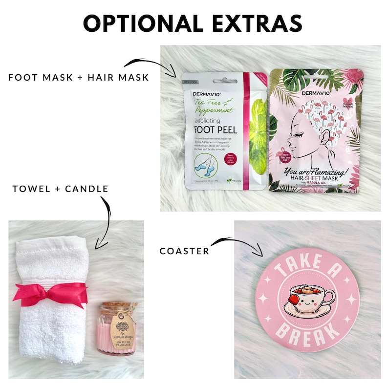May include: A pink and white gift basket with optional extras. The basket includes a white towel with a pink ribbon, a small glass jar with a candle, a pink and white coaster with the text "Take a Break" and a cup of tea, and two packets of face masks. One packet is green and says "Tea Tree & Peppermint Exfoliating Foot Peel" and the other is pink and says "You are Flamazing! Hair Sheet Mask Marula Oil".