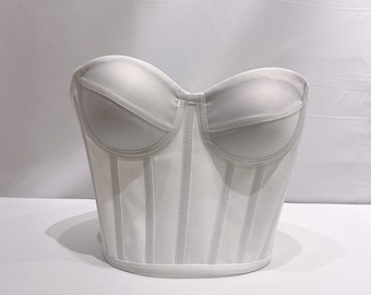 May include: A white strapless corset top with vertical seams and a boned bodice.