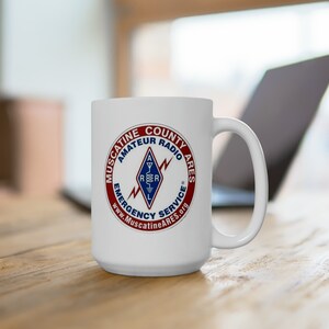 May include: White ceramic coffee mug with a red, white, and blue logo that reads "Muscatine County Amateur Radio Ares Emergency Service www.MuscatineARES.org"