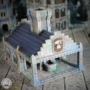 Pode incluir: Um edifício em miniatura detalhado com um telhado de telhas azuis, uma torre de pedra e um arco de pedra. O edifício é pintado em tons de cinza, azul e verde, e apresenta uma pequena placa de madeira com um símbolo de martelo e bigorna.