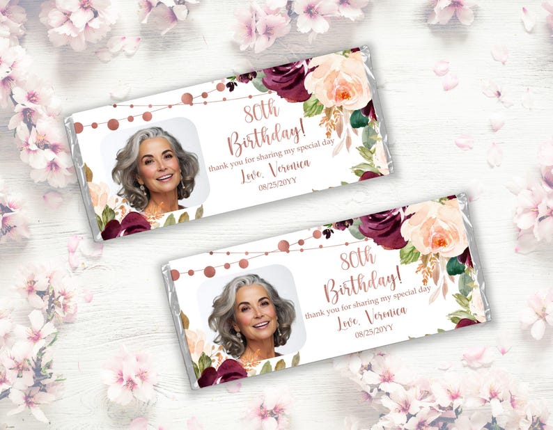 May include: A white chocolate bar with a floral design and a photo of a woman. The text on the bar reads "80th Birthday! Thank you for sharing my special day. Love, Veronica 08/25/20YY".