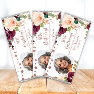May include: Three chocolate bar wrappers with a floral design in shades of pink and burgundy. The wrappers feature a photo of a woman and the text "80th Birthday!" with a personalized message.