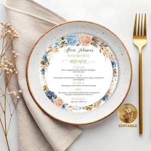 Puede incluir: Un menú de cumpleaños para el 80 aniversario, con un diseño de corona floral con flores azules y melocotón. El menú está en un plato blanco con cubiertos dorados. El texto dice "Menú 80 cumpleaños de Alicia Johnson."