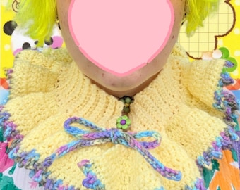 Può includere: Un colletto all'uncinetto giallo fatto a mano con bordo smerlato nei toni del viola, blu e grigio. Il colletto presenta un fiocco decorativo dai colori pastello e una chiusura con bottone a forma di fiore. Questo accessorio unico aggiunge un tocco di fantasia.