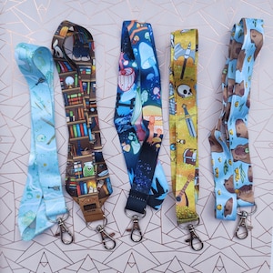 May include: Five colourful lanyards with different designs. The lanyards are made of a soft, durable material and feature a variety of fun and whimsical patterns. The lanyards are perfect for holding keys, ID badges, or other small items.