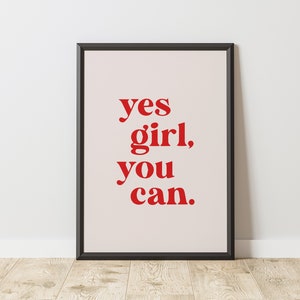 May include: A framed print with the text "yes girl, you can." in red letters on a white background.