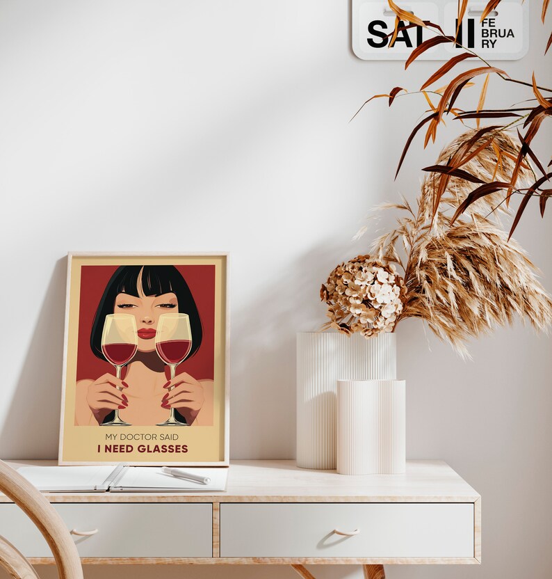 May include: A framed poster with a red background and a woman with black hair holding two glasses of red wine. The text on the poster reads "My doctor said I need glasses."