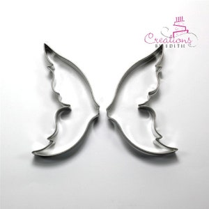 May include: Two silver metal cookie cutters shaped like butterfly wings.