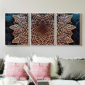 Puede incluir: Un tríptico de arte mural enmarcado con intrincados diseños de mandala marrón dorado sobre un fondo azul oscuro. La obra de arte se exhibe sobre un sofá con cojines rosas y grises, creando una declaración de decoración del hogar moderna y artística.