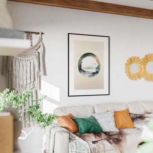 May include: A living room scene featuring a white sofa adorned with colorful pillows and a decorative throw. A framed artwork with a circular landscape design hangs above the sofa. Three round, woven wall mirrors add a touch of texture.
