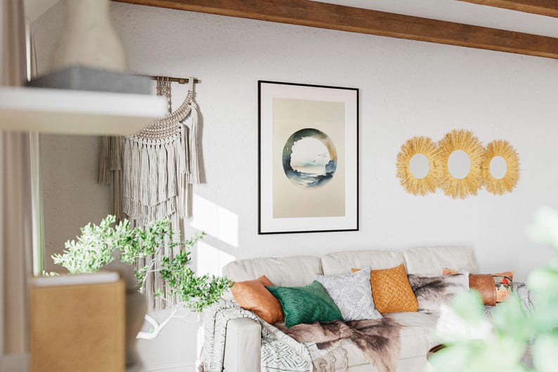 May include: A living room scene featuring a white sofa adorned with colorful pillows and a decorative throw. A framed artwork with a circular landscape design hangs above the sofa. Three round, woven wall mirrors add a touch of texture.