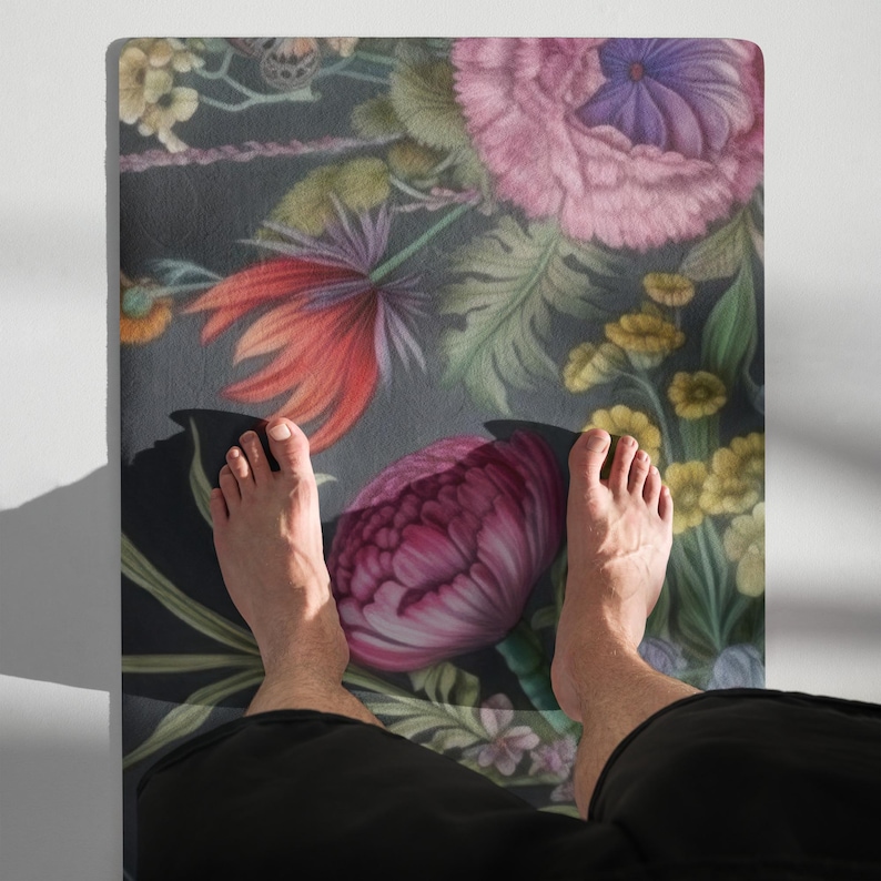 May include: A floral yoga mat featuring a dark background with large, colorful flowers in shades of pink, red, purple, and yellow. The mat has a detailed botanical design.