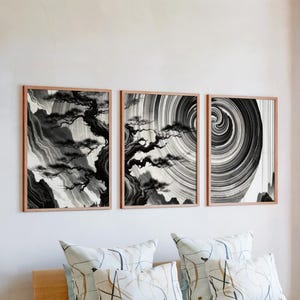 May include: A set of three ceramic mugs with a speckled, matte finish. The mugs are in shades of cream, light gray, and dark gray. Each mug has a simple, minimalist design, perfect for coffee or tea.