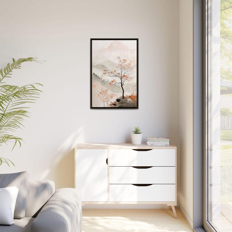 May include: A framed watercolour painting of a misty mountain landscape with a single tree in the foreground. The painting is in shades of grey, brown, and pink.