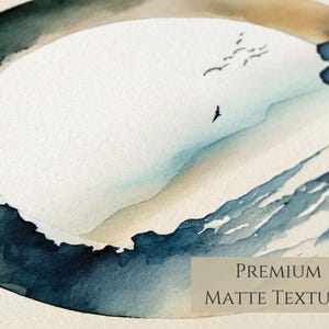 May include: Watercolor painting of a coastal landscape with a white oval in the center, surrounded by blue and beige tones. The image includes flying birds and the text "PREMIUM MATTE TEXTURE".