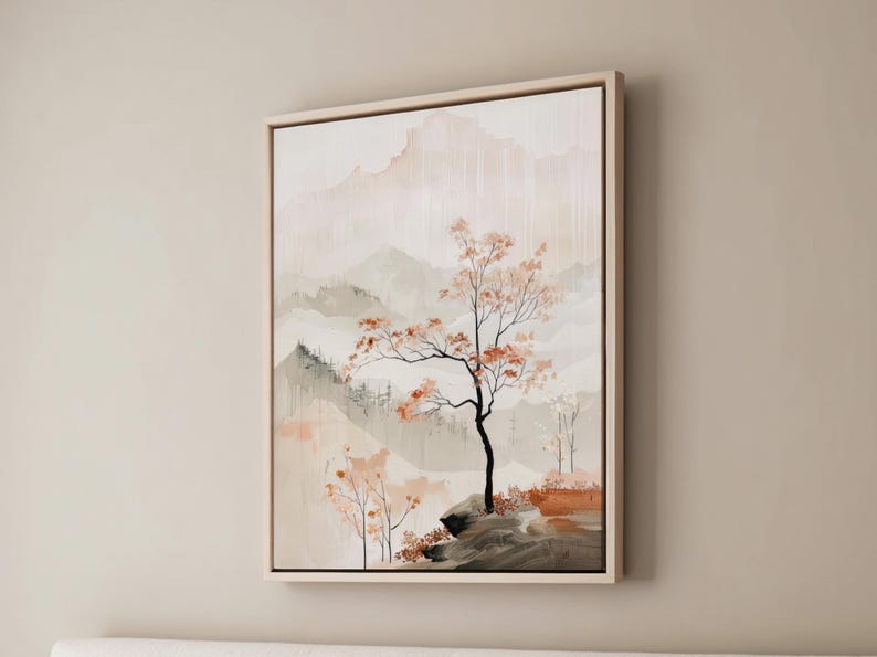 May include: A framed painting depicting a misty mountain landscape with a solitary tree in the foreground. The tree has delicate branches and leaves in shades of brown and orange. The background is a soft blend of pale pink, grey, and white.