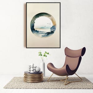 May include: A framed watercolor print featuring a circular landscape scene with a blue and green color palette. The artwork hangs above a modern brown chair with gold legs, a small side table, and a vase with greenery.