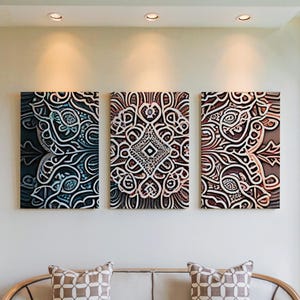 Puede incluir: Tres obras de arte murales rectangulares con intrincados diseños abstractos en tonos de azul, marrón y blanco. La obra de arte está montada en una pared de color neutro, encima de un sofá con cojines estampados. La habitación está bien iluminada.