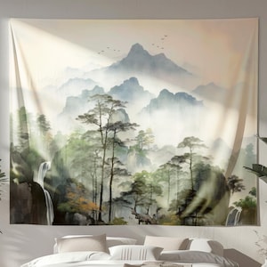 May include: A large wall tapestry featuring a serene landscape painting. The artwork depicts misty mountains, lush green trees, and a waterfall. The color palette includes shades of green, blue, and beige, creating a calming atmosphere. The tapestry is hung above a bed.