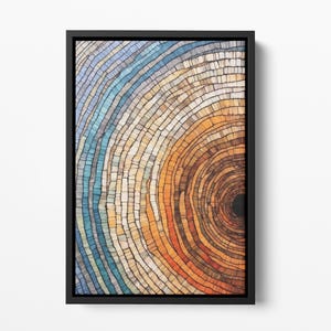 Puede incluir: Impresión de arte abstracto con un patrón circular de anillos concéntricos en tonos de azul, beige, naranja y rojo. Los anillos están formados por pequeños cuadrados, creando un efecto de mosaico. El centro del círculo es negro.