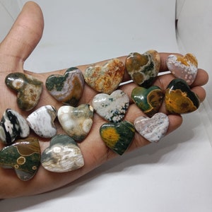 May include: A collection of 14 heart-shaped polished stones with various patterns of green, brown, white, and yellow.