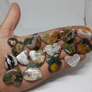 May include: A collection of 14 green, brown, and white heart-shaped polished stones. The stones have a unique marbled pattern.