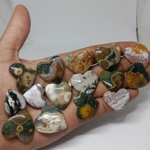 May include: A collection of 15 heart-shaped polished stones with a variety of green, brown, white, and yellow patterns.