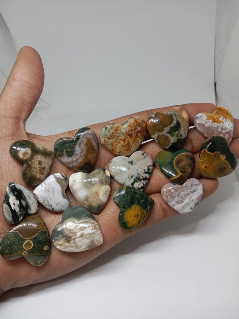 May include: A collection of 15 heart-shaped polished stones with a variety of green, brown, white, and yellow patterns.