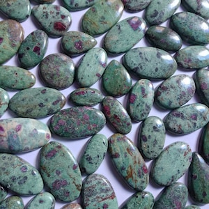 May include: A collection of oval-shaped green and pink stones with a speckled pattern. The stones are smooth and polished.