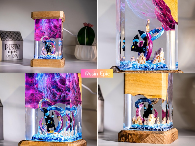 May include: A rectangular resin lamp featuring a black Umbreon figure encased in clear resin with swirling purple and pink smoke effects. The lamp has a wooden base and top, with a base of blue and white textured material resembling water.