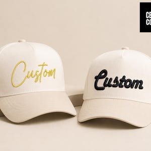 Peut inclure: Deux casquettes de baseball avec une couronne crème et une visière beige. L'une porte la broderie "Custom" en or, l'autre en noir. Les casquettes sont présentées sur un fond neutre. La marque "CELLY CO." est dans un encadré noir.