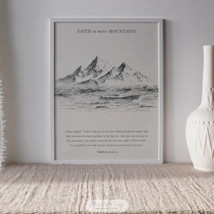 Może przedstawiać: Oprawiony czarno-biały wydruk z napisem "FAITH to move MOUNTAINS" nad ilustracją góry i morza. Poniżej ilustracji znajduje się werset biblijny z Ew. Mateusza 21:21-22. Po prawej stronie znajduje się biały wazon.